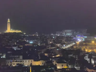 a view of a city at night with a lighthouse at Melines in Casablanca