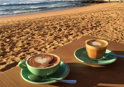 two cups of coffee on a table on the beach at Charmant Appartement avec une vue imprenable in Tamaris