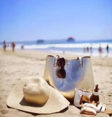 a hat and sunglasses and a purse on the beach at Charmant Appartement avec une vue imprenable in Tamaris