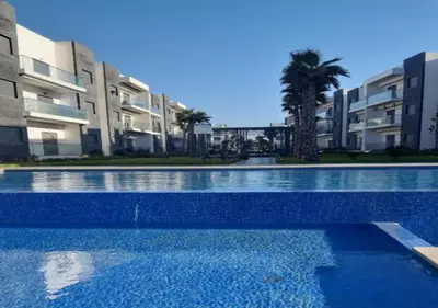 a swimming pool in front of some apartment buildings at Charmant Appartement avec une vue imprenable in Tamaris