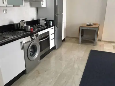a kitchen with a stove and a washing machine at Appartement près de Novotel face au parc WELCOME STAY in Mohammedia