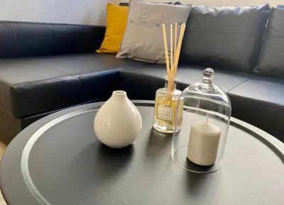 a table with a candle and a bottle and a couch at Appartement près de Novotel face au parc WELCOME STAY in Mohammedia