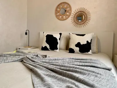 a bed with a black and white blanket on it at Appartement près de Novotel face au parc WELCOME STAY in Mohammedia