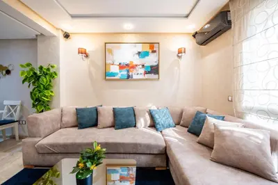 a living room with a brown couch and blue pillows at Casa Lucia Family Flat Optical Fiber in Rabat