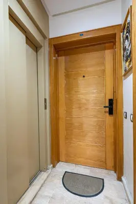 a wooden door in a hallway with a rug at Casa Lucia Family Flat Optical Fiber in Rabat