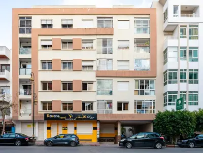 a building with cars parked in front of it at Casa Lucia Family Flat Optical Fiber in Rabat