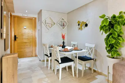 a dining room with a white table and chairs at Casa Lucia Family Flat Optical Fiber in Rabat