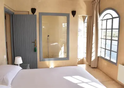 a bedroom with a white bed and a mirror at L'Oum Errebia in Azemmour