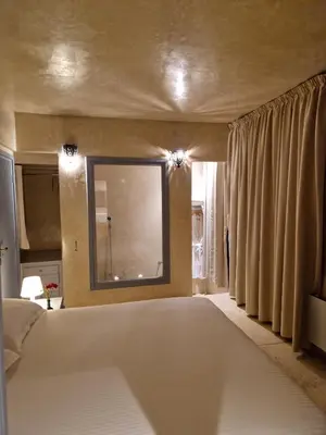 a bedroom with a large bed and a large mirror at L'Oum Errebia in Azemmour