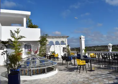 a patio with tables and chairs in front of a building at L'Oum Errebia in Azemmour