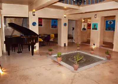 a living room with a piano and a dining area at L'Oum Errebia in Azemmour