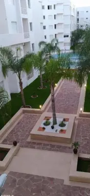 a courtyard with a fountain and palm trees in a building at Jnane dalia in Bouznika
