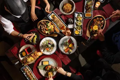 a group of people sitting around a table with food at Radisson Blu Hotel Casablanca City Center in Casablanca