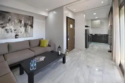 a living room with a couch and a table at Le Yacht Suites Hotel in Casablanca