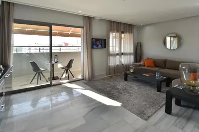 a living room with a couch and a table at Le Yacht Suites Hotel in Casablanca
