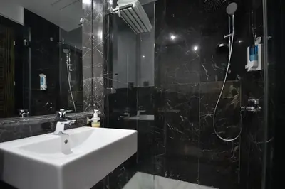 a bathroom with a white sink and a shower at Le Yacht Suites Hotel in Casablanca