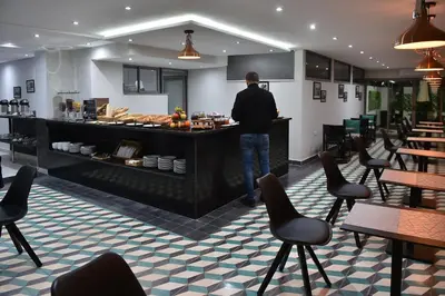 a man standing at a counter in a restaurant at Le Yacht Suites Hotel in Casablanca