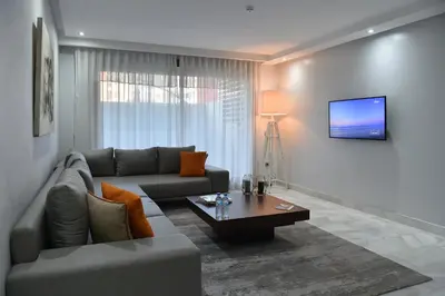a living room with a couch and a table at Le Yacht Suites Hotel in Casablanca
