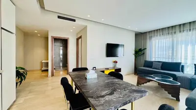 a living room with a table and a blue couch at City Center Apartment with Terrace in Casablanca
