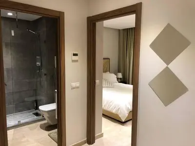 a bathroom with a toilet and a bedroom with a bed at City Center Apartment with Terrace in Casablanca