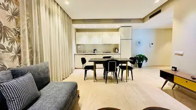 a living room and kitchen with a table and chairs at City Center Apartment with Terrace in Casablanca
