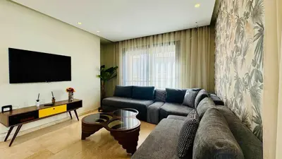 a living room with a couch and a flat screen tv at City Center Apartment with Terrace in Casablanca