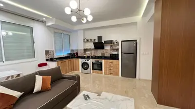 a living room with a couch and a kitchen at Petit nid douillé au coeur de Casablanca in Casablanca