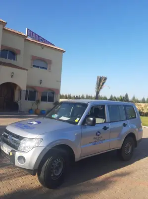 a white suv parked in front of a house at Riad TANJIL in Casablanca