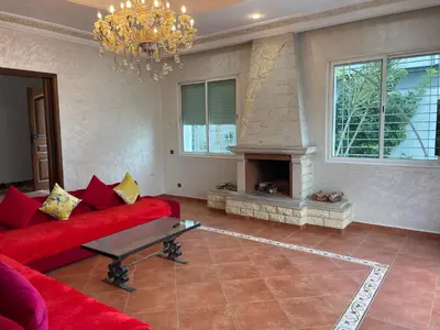 a living room with a red couch and a fireplace at Luxury Villa at Ain-Diab in Casablanca