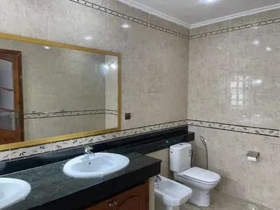 a bathroom with a sink and a toilet and a mirror at Luxury Villa at Ain-Diab in Casablanca