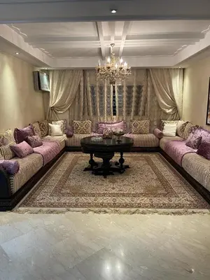 a living room with couches and a table and a chandelier at Appartement de luxe in Casablanca