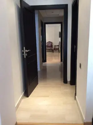 a hallway with an open door leading to a room at Appartement de luxe in Casablanca