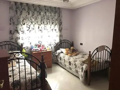 a bedroom with two beds and a window at Aznavour room in Casablanca