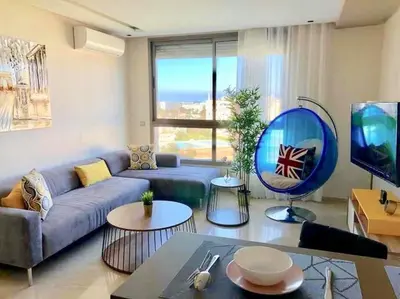 a living room with a blue couch and a large window at Luxury Top Floor, Casablanca Center... in Casablanca