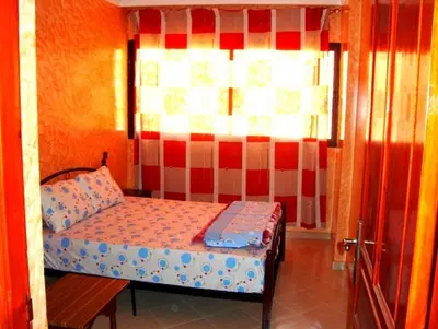a small bedroom with a bed and a window at Silia Appartements in Temara