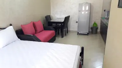 a room with a bed and a table and chairs at Silia Appartements in Temara