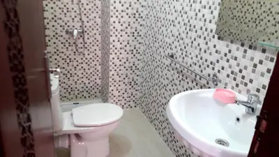 a bathroom with a toilet and a sink at Silia Appartements in Temara