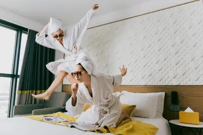 two people jumping on a bed in a hotel room at New Hotel Piscine Wellness & Spa in Casablanca
