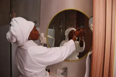 a woman in a bathroom mirror brushing her teeth at New Hotel Piscine Wellness & Spa in Casablanca