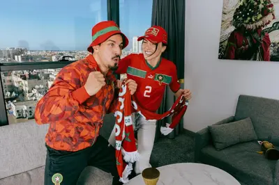 two men are standing in a living room playing a video game at New Hotel Piscine Wellness & Spa in Casablanca