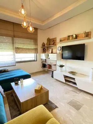 a living room with a blue couch and a tv at BEST unit NEAR Casablanca AIRPORT in Casablanca