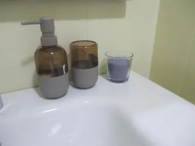 a bottle of soap and two glasses on a sink at Mosquee & Sea View Casablanca in Casablanca