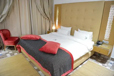 a bedroom with a large bed with a red towel on it at Aralia Boutique Hôtel in Rabat