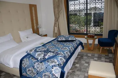 a bedroom with a bed with a blue and white blanket at Aralia Boutique Hôtel in Rabat