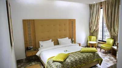 a bedroom with a large white bed and a window at Aralia Boutique Hôtel in Rabat