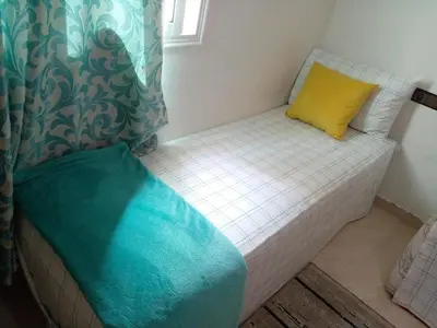 a small bed with a yellow pillow on it at Dar Khalifa Airport in Nouaseur