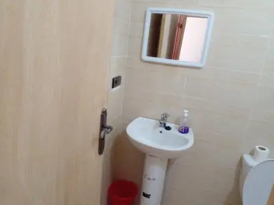 a bathroom with a sink and a mirror and a toilet at Dar Khalifa Airport in Nouaseur