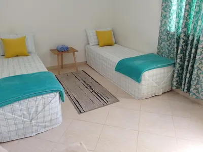 a living room with two chairs and a couch at Dar Khalifa Airport in Nouaseur