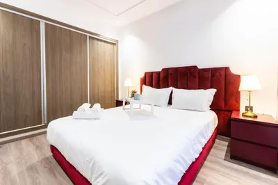 a bedroom with a large white bed with a large headboard at Stylish & Chic Flat - Best Place - New Building in Casablanca