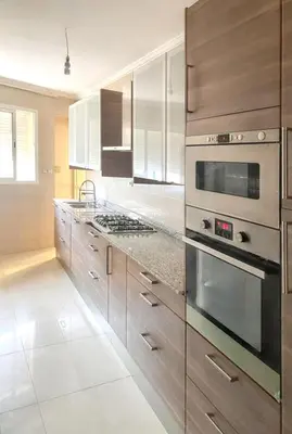 a kitchen with stainless steel appliances and wooden cabinets at Spacious apartment in Nouaseur of 167 m² in Nouaseur